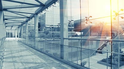مبنى زجاجي حديث يحتوي على ممر زجاجي بالكامل